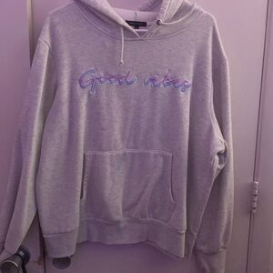 grey "good vibes" hoodie with purple and blue writing